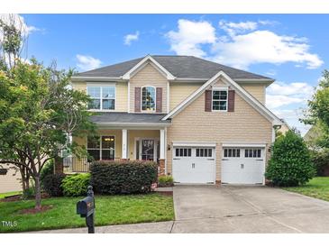 Charming two-story home featuring a well-manicured lawn, inviting porch, and a convenient two-car garage at 210 Strolling Way, Durham, NC 27707
