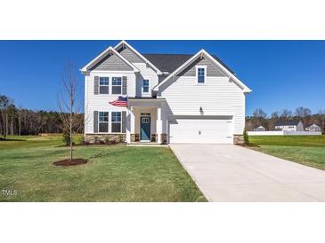 Charming two-story home with white siding, a well-manicured lawn, and an attached two-car garage at 267 Old Fashioned Way, Lillington, NC 27546