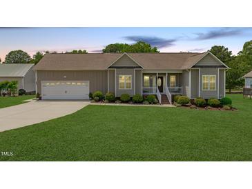 Charming single-story home featuring a well-manicured lawn and an attached two-car garage at 402 S Wilma St, Angier, NC 27501