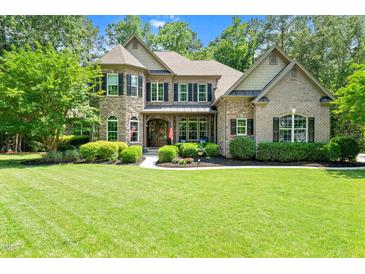 Charming two-story home with a well-manicured lawn and beautiful landscaping at 7552 Hasentree Club Dr, Wake Forest, NC 27587