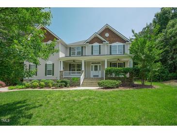 Charming two-story home with inviting front porch and meticulously landscaped lawn at 1005 Hidden River Ct, Raleigh, NC 27614