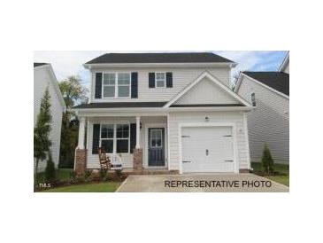 Charming two-story home featuring a well-manicured lawn and a cozy front porch at 103 Goldenrod Loop, Clayton, NC 27520