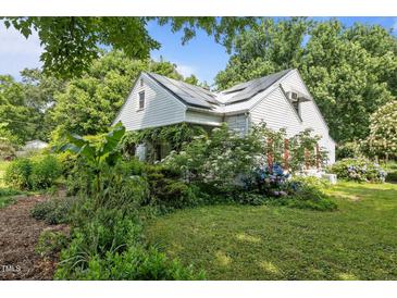 Charming home with a white exterior and beautiful landscaping with lots of curb appeal at 1090 S Fifth St, Mebane, NC 27302