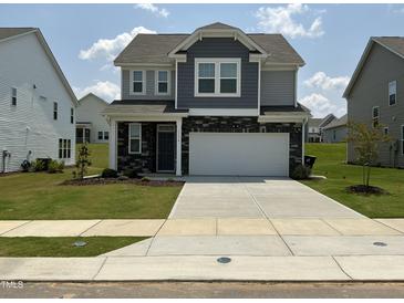 Charming two-story home with stone accents, a two-car garage, and well-manicured lawn at 1116 Sidney Creek Dr # 1116, Zebulon, NC 27597