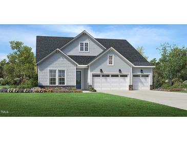 Charming two-story home featuring a three-car garage, light blue siding and a well-manicured lawn at 2129 Abbeyhill Dr # 89, Raleigh, NC 27610