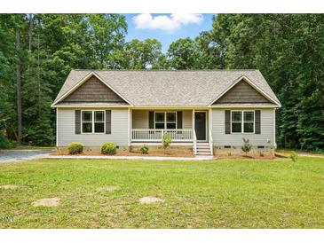 Charming single-story home with a cozy front porch and well-manicured lawn surrounded by mature trees at 39 Blue Heron Ct, Kenly, NC 27542