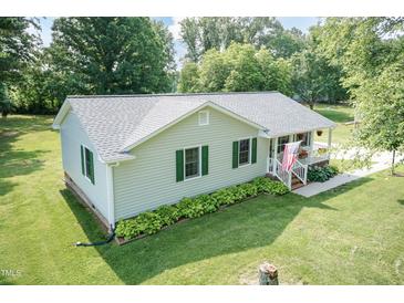 Charming ranch home features a covered porch, green shutters, and mature landscaping at 523 Edwards Rd, Henderson, NC 27537