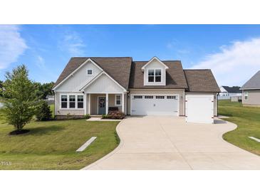 Charming single-Gathering home featuring a manicured lawn, and an attached two-car garage at 80 Shallow Falls Ln, Benson, NC 27504