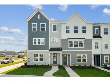 Charming townhome showcasing a beautifully landscaped lawn, inviting entrance, and stylish multi-tone exterior at 800 Hillfarm Dr, Wake Forest, NC 27587