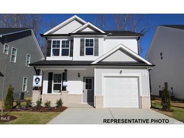 Charming two-story home featuring a white exterior, a garage, and a well-maintained front yard at 95 Goldenrod Loop, Clayton, NC 27520
