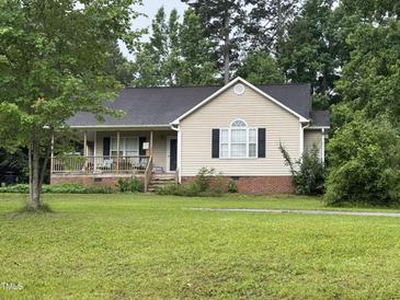 Charming single-story home with a welcoming front porch and well-manicured lawn at 104 Holly Ranch Ct, Willow Springs, NC 27592