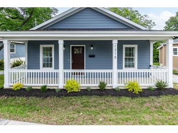 Charming blue home with a welcoming front porch and manicured landscaping at 1318 N Alston Ave, Durham, NC 27701