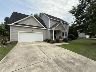 Charming two-story home featuring a gray exterior, attached garage and manicured lawn at 148 Langston Ridge Dr Dr, Angier, NC 27501