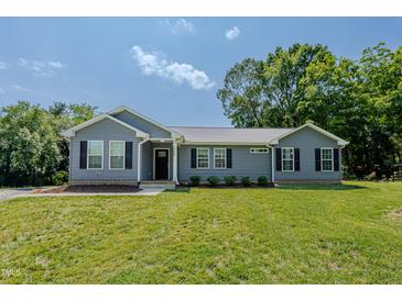 Charming single-story home featuring blue siding, black shutters, and a well-manicured lawn at 169 Forest Dr, Graham, NC 27253