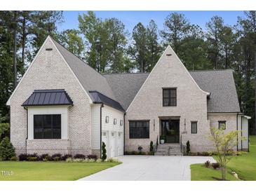 Stunning brick home boasts a manicured lawn, attached garage, and stately architectural details at 2713 Trifle Lane Ln, Wake Forest, NC 27587
