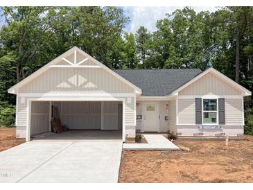 Charming one-story home featuring an attached two-car garage and neutral siding, awaiting your personal touch at 311 Rothbury Ct, Sanford, NC 27330