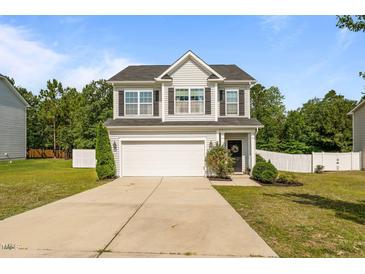 Charming two-story home with a two-car garage and a well-manicured lawn with an inviting entrance at 315 Watchmen Ln, Cameron, NC 28326