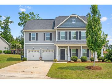 Charming two-story home features a manicured lawn and attached two-car garage at 33 E Ravano Dr, Clayton, NC 27527