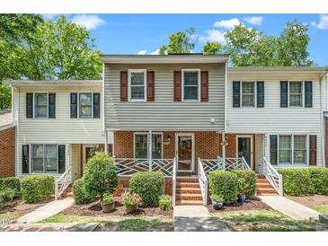 Charming townhouse with a brick facade, tidy landscaping, and a welcoming front porch in a residential setting at 4604 Townesbury Ln, Raleigh, NC 27612