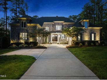 Stunning stone home exterior featuring elegant architectural details and a lush, landscaped yard at 7545 Hasentree Club Dr, Wake Forest, NC 27587