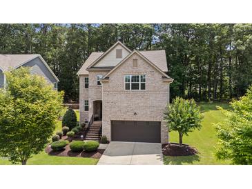 Two-story brick home featuring an attached garage and well-manicured front lawn at 8132 Wheeler Woods Dr, Apex, NC 27539