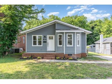Charming gray home featuring a welcoming front porch and well-maintained lawn at 828 Cotton Pl, Raleigh, NC 27601