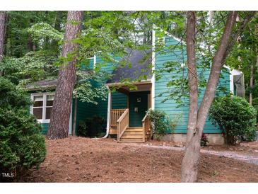 Charming home with green siding, wooden stairs to the front door, and mature trees at 90 Oak Leaf Ln, Chapel Hill, NC 27516
