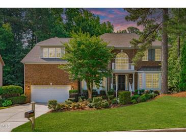 Stately brick home with lush landscaping, attached garage, and mature trees at 101 Quarryrock Rd, Holly Springs, NC 27540