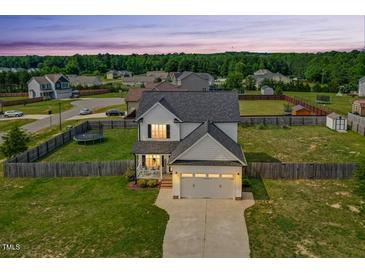 Charming two-story home with a well-manicured lawn and a two-car garage at 102 Williamson Place Dr, Princeton, NC 27569
