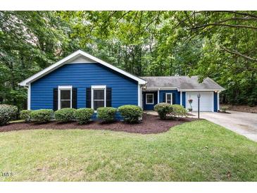 Charming blue home with lush green lawn and mature trees creating a serene outdoor space at 103 Summerlin Dr Dr, Chapel Hill, NC 27514