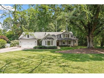 Charming single-story home featuring a manicured front lawn and attached two-car garage at 124 Lord Ashley Rd, Raleigh, NC 27610
