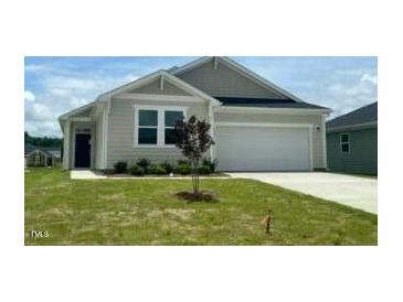 Charming one-story home featuring a two-car garage, complemented by a well-manicured lawn and inviting curb appeal at 125 Fraiser Fir Way, Lillington, NC 27546