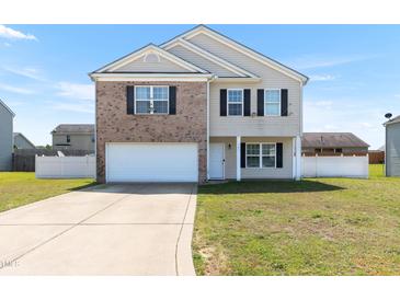 Charming two-story home with a brick front and a well-maintained front lawn at 131 Botanical Ct, Bunnlevel, NC 28323