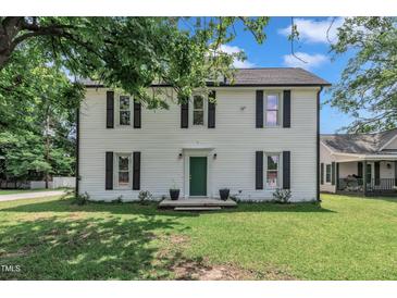 Charming two-story home with white siding, black shutters, and a well-maintained front yard at 141 S Broad E St, Angier, NC 27501