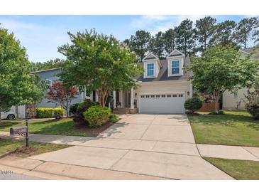 Charming home featuring a well-manicured lawn, mature trees, and a welcoming two-car garage at 1612 Old Bramble Ln, Fuquay Varina, NC 27526