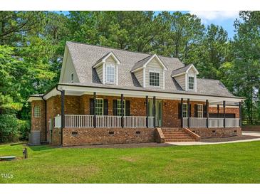 Charming brick home featuring a welcoming front porch with columns and dormer windows at 2015 Saddlebrook Dr, Archer Lodge, NC 27527