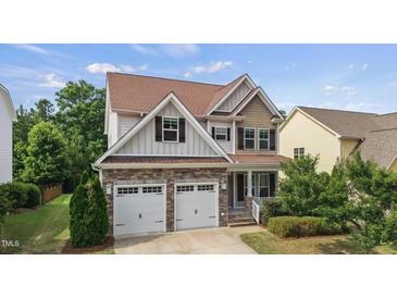 Charming two-story home with a stone facade, attached two-car garage, and beautifully landscaped front yard at 2256 Toad Hollow Trl, Apex, NC 27502