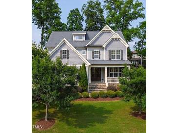 Beautiful two-story home with a manicured lawn, mature trees, and a welcoming front porch at 2661 Silver Bend Dr, Apex, NC 27539