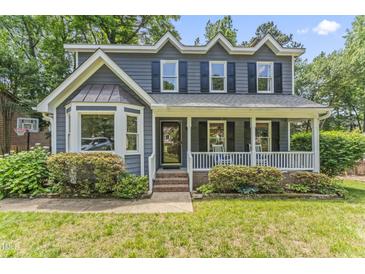 Charming two-story home with a covered front porch, well-maintained lawn, and manicured landscaping at 2708 Halfhitch Trl, Raleigh, NC 27615