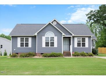 Charming single-story home with a well-maintained lawn, stylish gray siding, and white trim at 308 E Quailwood Dr, Fuquay Varina, NC 27526