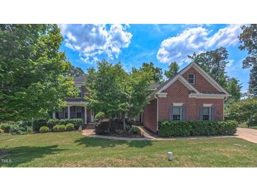 Charming brick home with lush landscaping, mature trees and a well-manicured lawn at 3408 Mount Pisgah Way, Cary, NC 27519