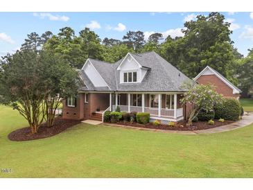 Inviting brick home with a well-manicured lawn and charming front porch at 3912 Kildrummy Dr, Durham, NC 27705