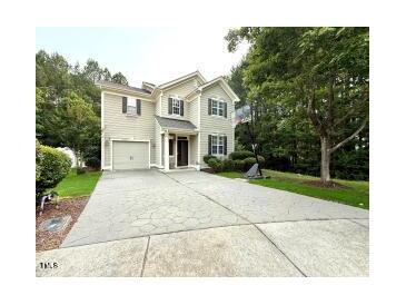 Charming two-story home featuring a garage and a beautifully patterned concrete driveway at 407 Elm Farm Pl, Morrisville, NC 27560