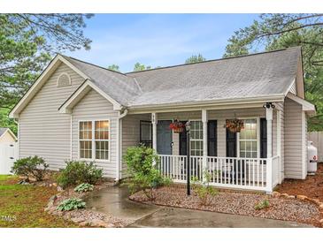 Charming home with a cozy front porch, complete with hanging flower baskets and a well-manicured garden at 50 Rainwood Ct, Louisburg, NC 27549