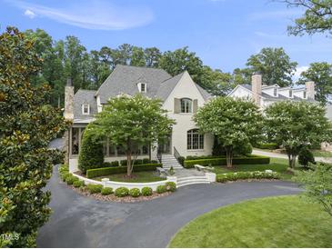 Stunning exterior of a white painted brick home with manicured landscaping and an asphalt driveway at 504 Yarmouth Rd, Raleigh, NC 27608