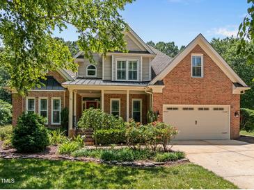 Beautiful brick home with manicured lawn, covered porch, and two-car garage at 5108 Briton Pl, Fuquay Varina, NC 27526