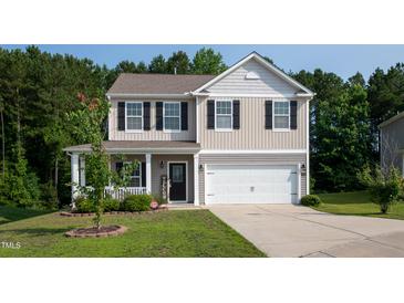 Charming two-story home with a well-manicured lawn and a welcoming front porch and two-car garage at 6729 Osprey Landing Dr, Wendell, NC 27591