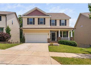 Charming two-story home with a well-manicured lawn, attached two-car garage, and inviting front porch at 817 Stable Fern Dr, Fuquay Varina, NC 27526