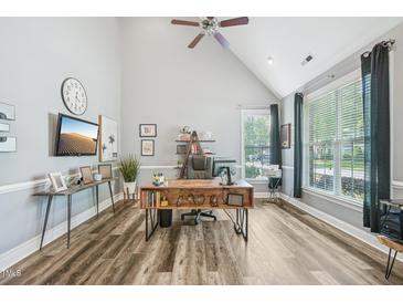 Bright home office with vaulted ceilings, wood floors, large windows, and rustic wooden desk at 9530 Vira Dr, Raleigh, NC 27617
