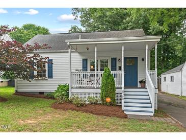 Charming home with a welcoming porch, a blue door, white columns, and updated landscaping at 1826 Northgate St, Durham, NC 27704